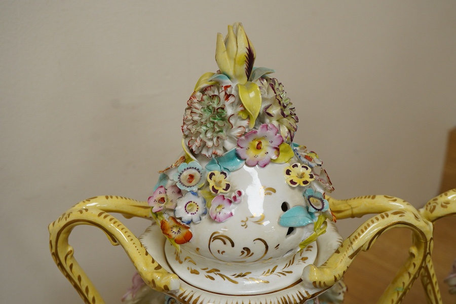 A pair of English porcelain floral encrusted vases and covers, c.1830, possibly Samuel Alcock, each painted with landscapes, 44cm high